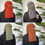 Collage of four images showing a woman in various colors of niqab, including red, gray, green, and orange, in an indoor setting.